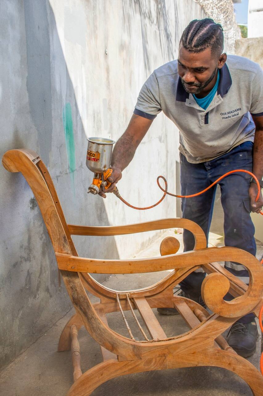 Artisan vernissant un fauteuil au pistolet