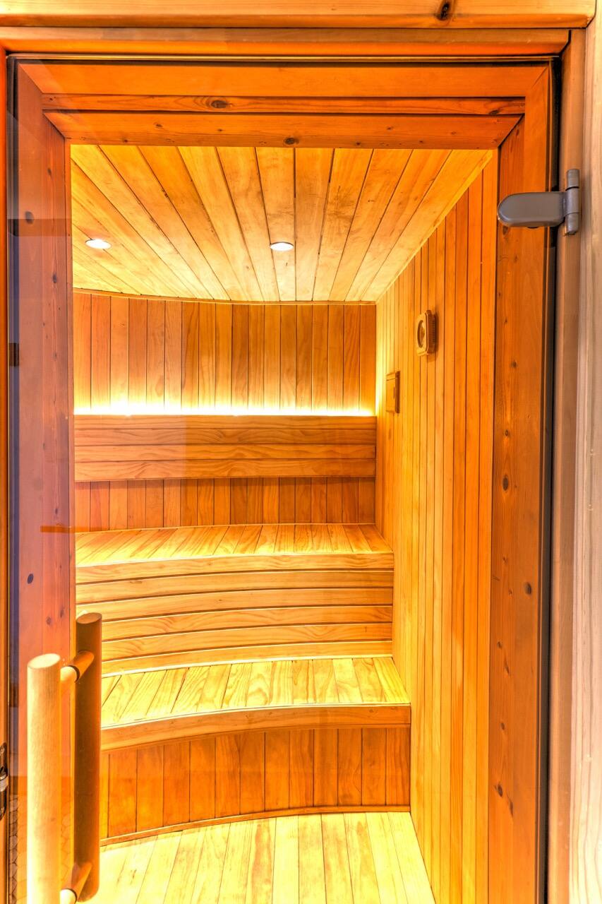 Sauna en bois clair vu par sa porte ouverte